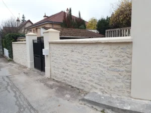 Ravalement et rénovation d'un mur de clôture en pierre — enduit imitation pierre finition grattée — AMEX Façade